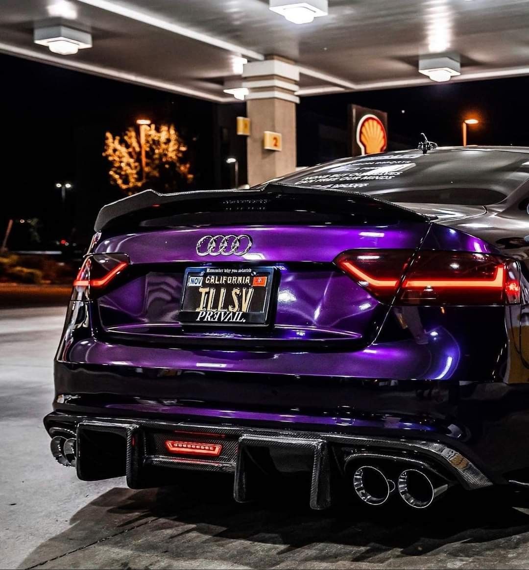 Rear view of an Audi RS silhouette in Midnight Purple Metallic at night